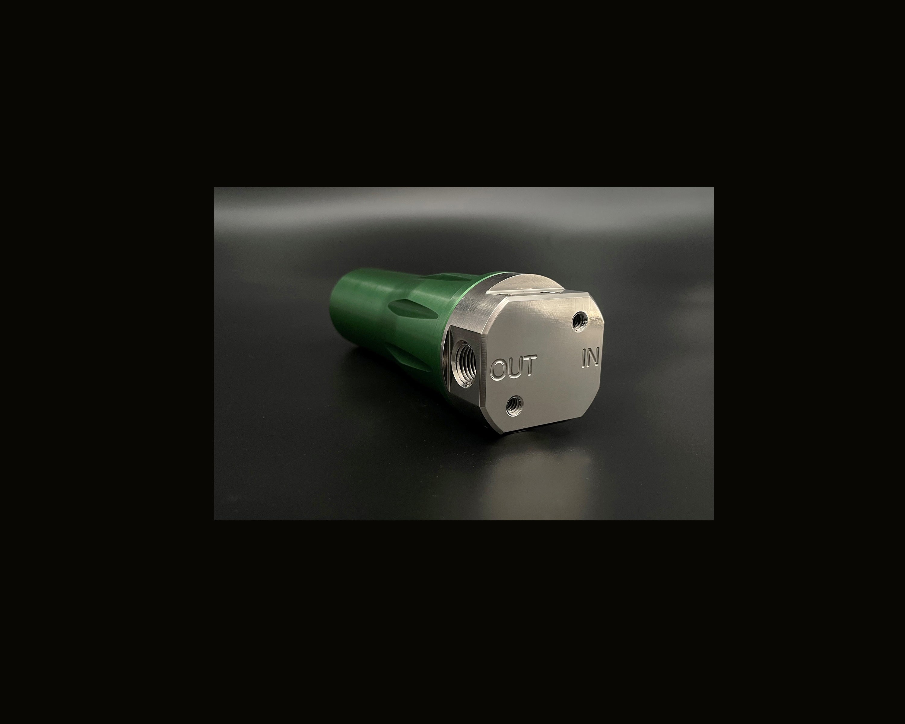 Mechanical component with 'OUT' and 'IN' labels on a dark background
